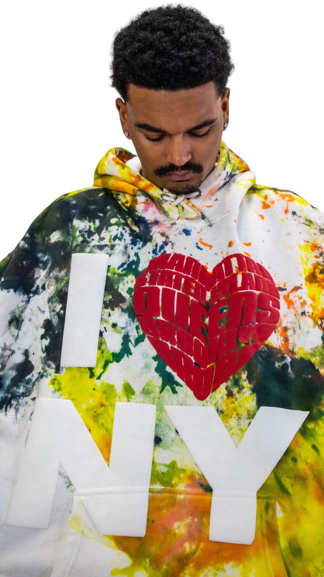 Close-up of a tie-dye hoodie showing the detail of the textured, three-dimensional red heart and white puff-print letters of the 'I ❤️ NY' logo.
