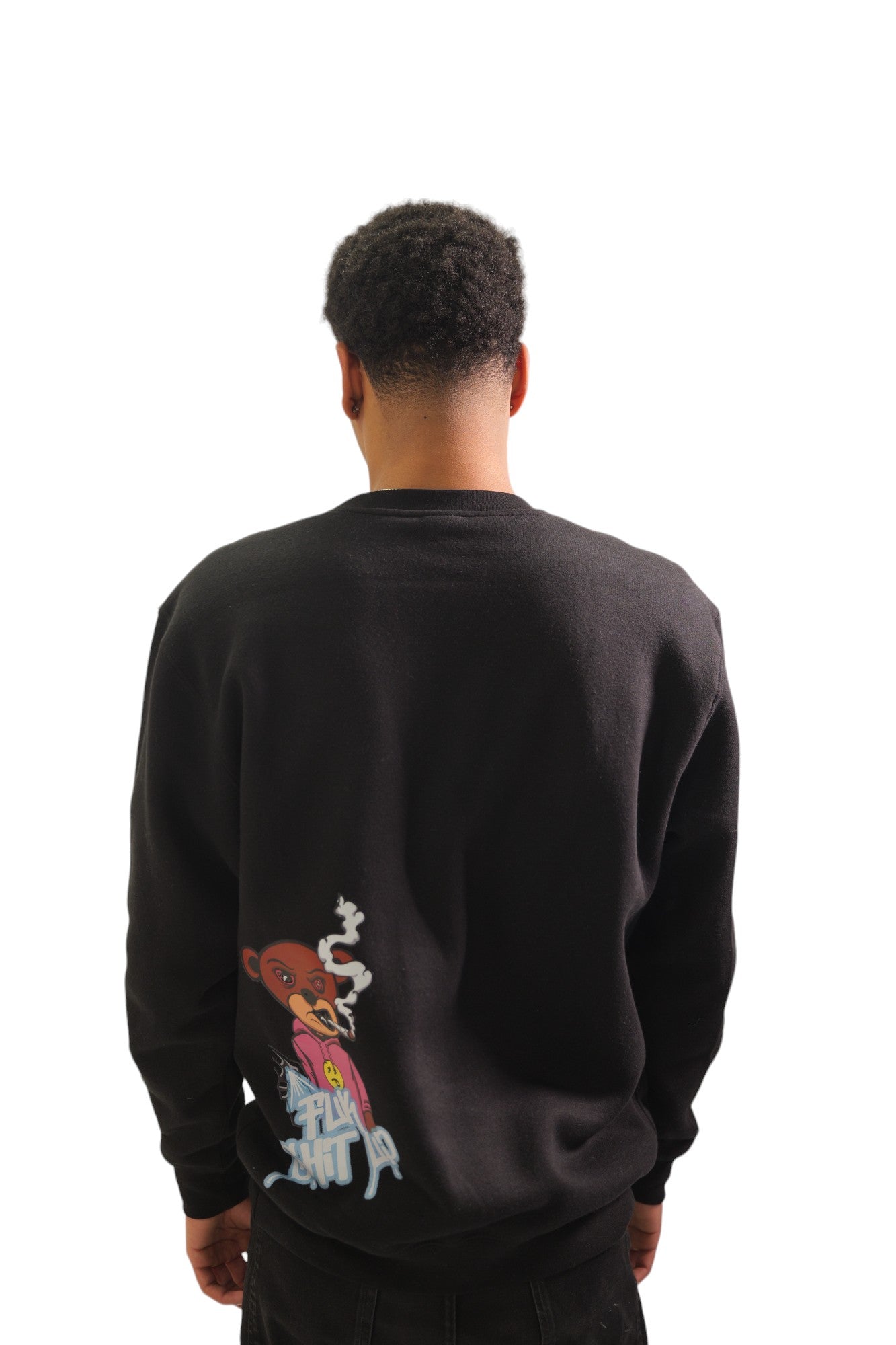 Back view of a model wearing a black crewneck sweatshirt. On the lower-left back is a small graphic of a cartoon bear and the words 'FUCK SHIT UP' in a graffiti-style font.