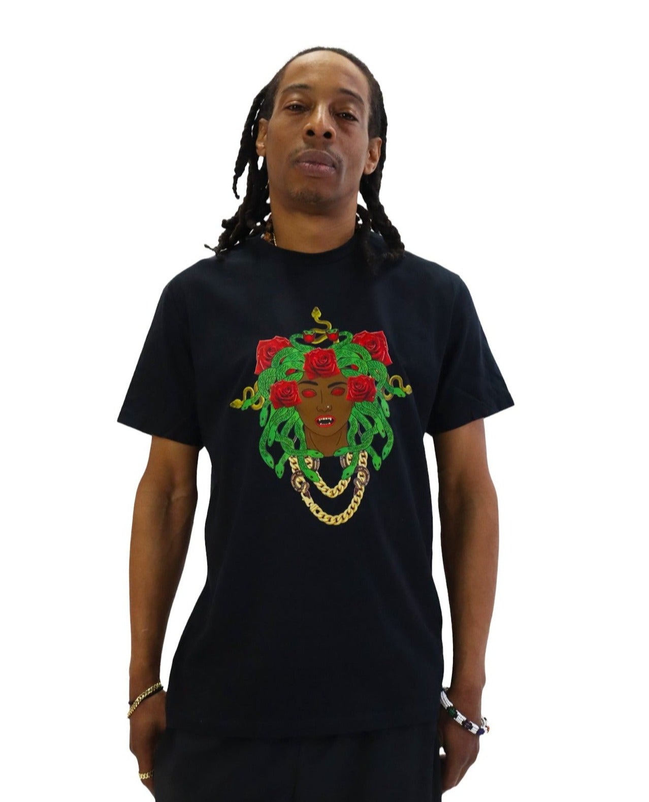 Front view of a model wearing a black t-shirt. The shirt features a large, colorful graphic of Medusa as a Black woman with green snakes and red roses for hair, glowing red eyes, and a gold chain necklace.