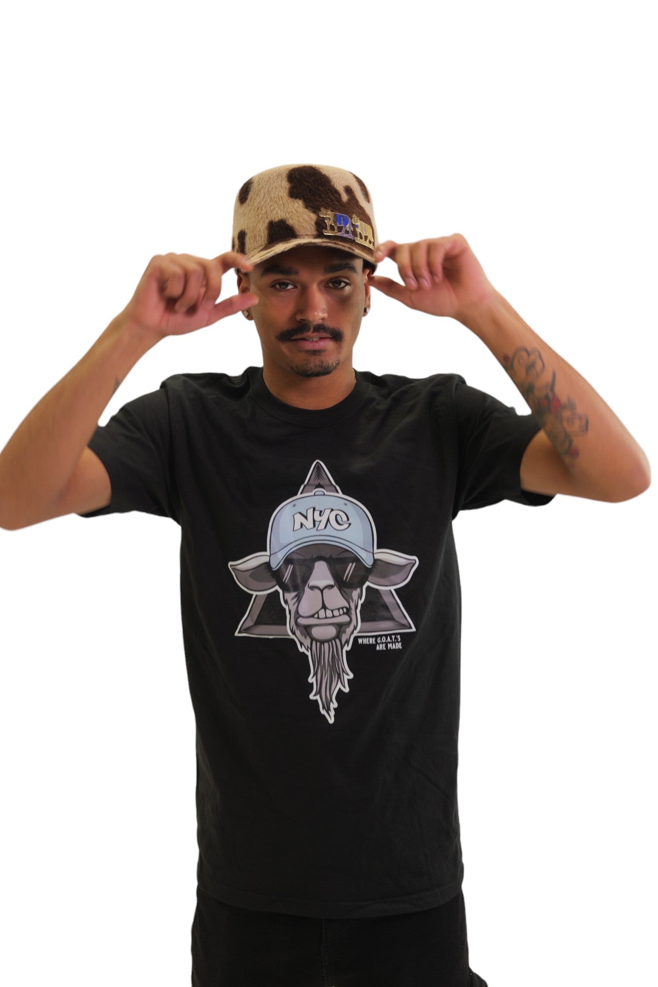 A model wearing a black t-shirt with a large graphic on the chest. The graphic features a cool-looking goat wearing sunglasses and an 'NYC' hat, set against a six-pointed star.