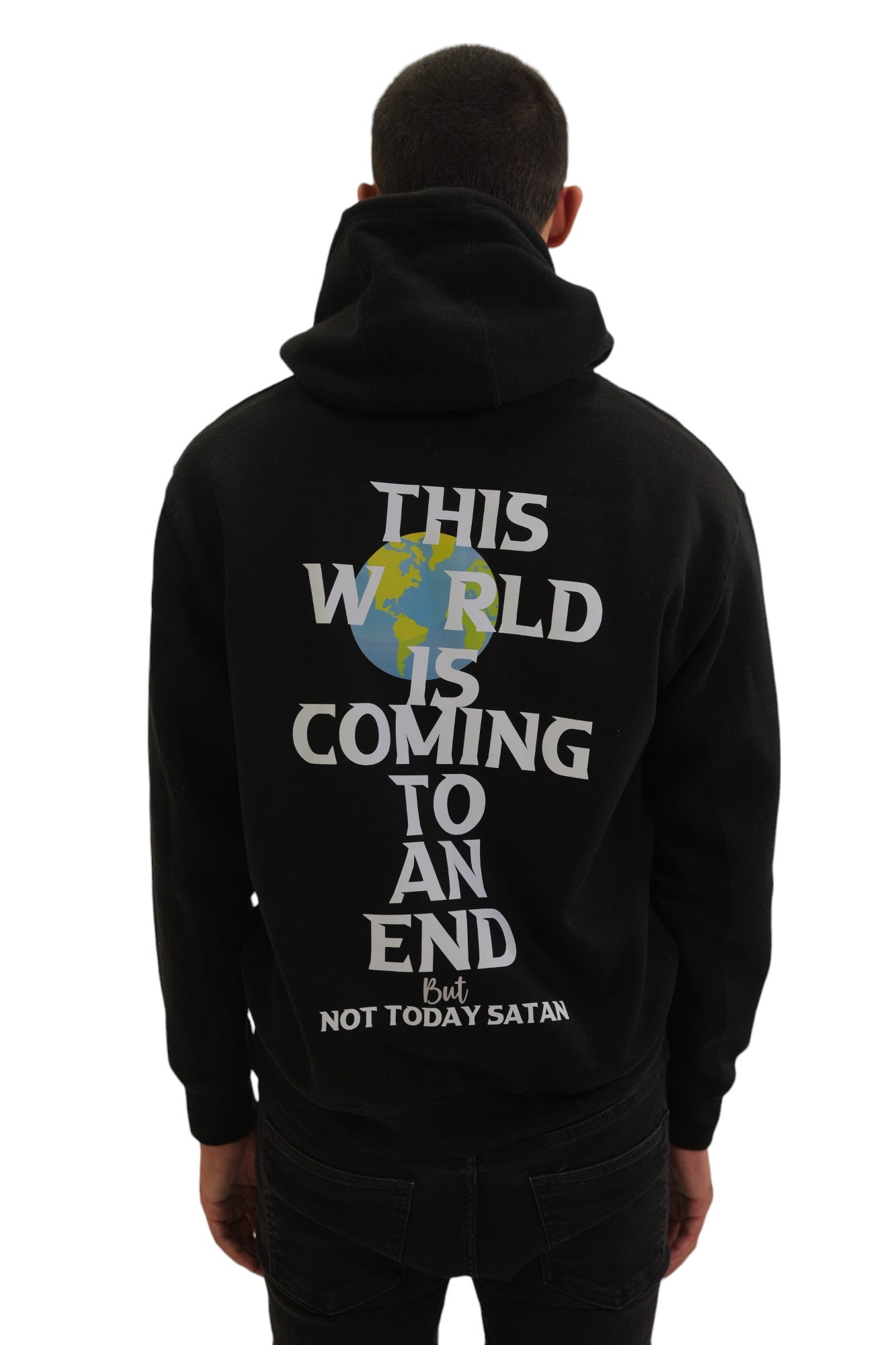 Back view of a model wearing a black hoodie. The back has large white text reading 'THIS WORLD IS COMING TO AN END' with a globe graphic, and smaller red text below that says 'But NOT TODAY SATAN'.