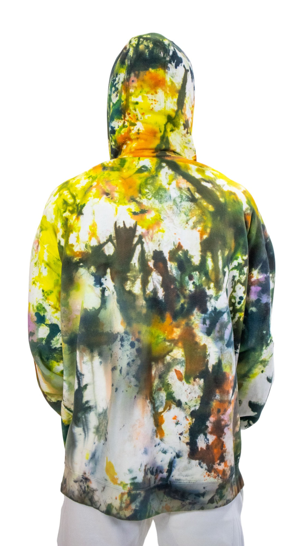 Back view of a model wearing a hoodie completely covered in a chaotic pattern of green, yellow, black, and orange ice-dye.
