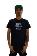 Front view of a model wearing a black t-shirt with the words 'New Yikes City' printed on the chest in a light blue, bubbly font.