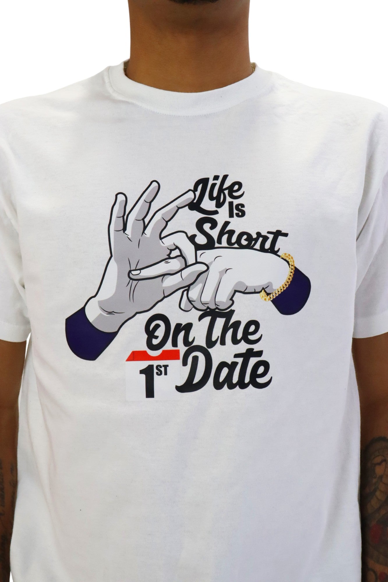 Front close up view of a model wearing a white t-shirt with a provocative graphic. The design combines text and hand gestures to convey the explicit phrase 'Life is short, fuck on the first date'.