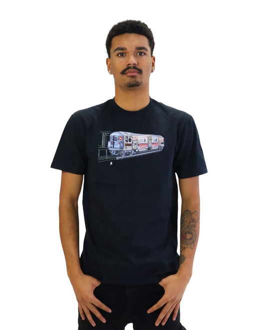 A man models a black t-shirt featuring a detailed graphic of a vintage New York City subway train. The entire side of the train car is covered in colorful, elaborate graffiti as it emerges from a dark tunnel.