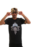 A model wearing a black t-shirt with a large graphic on the chest. The graphic features a cool-looking goat wearing sunglasses and an 'NYC' hat, set against a six-pointed star.