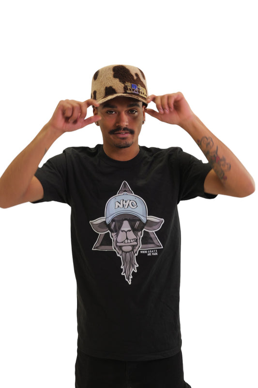 A model wearing a black t-shirt with a large graphic on the chest. The graphic features a cool-looking goat wearing sunglasses and an 'NYC' hat, set against a six-pointed star.