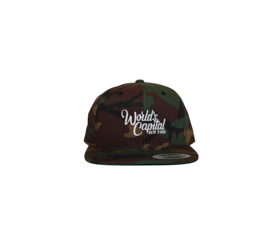 A snapback hat with a traditional green and brown woodland camouflage pattern. The words 'World's Capital of NEW YORK' are embroidered on the front in white.